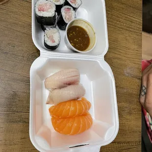 a person holding a plate of sushi