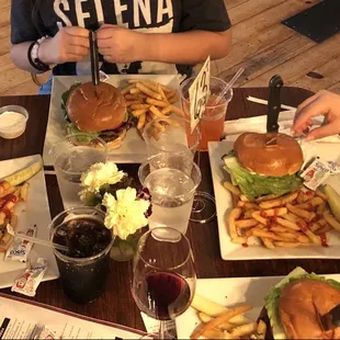 a table full of burgers and fries