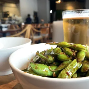 a bowl of edamado and a glass of beer