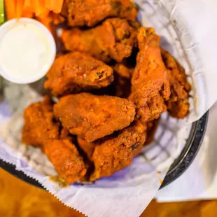 a basket of chicken wings and carrots