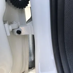 overspray in left front door behind door bracket