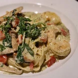 a plate of pasta with shrimp and spinach