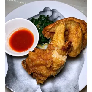 a plate of fried chicken and a bowl of sauce