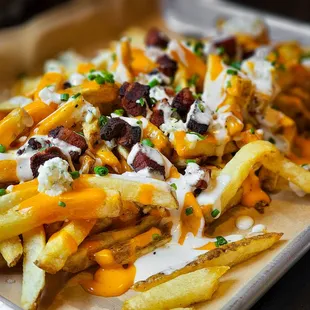 a tray of fries with cheese and bacon