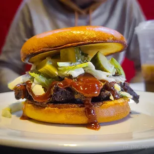 a man sitting at a table with a hamburger