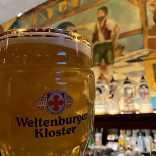 a glass of beer on a bar