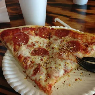 a slice of pepperoni pizza on a paper plate