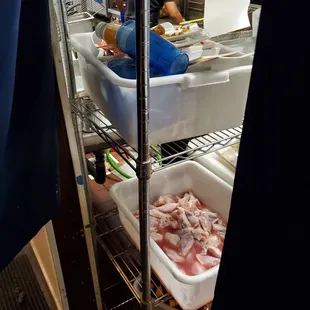 raw chicken stored under dirty dishes