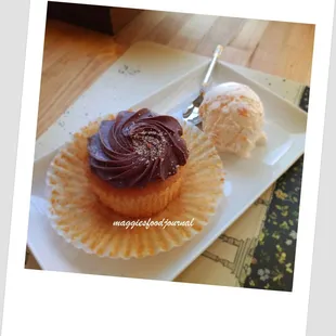 a cupcake with chocolate frosting and a scoop of ice cream