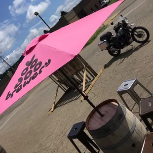 a pink umbrella over a barrel