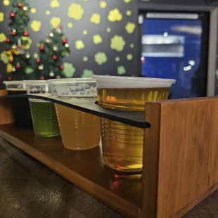 a row of plastic cups on a wooden shelf