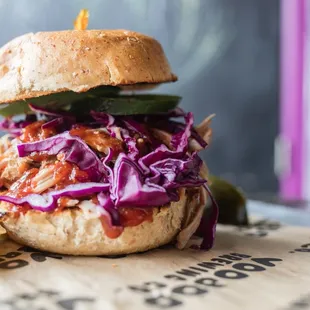 a pulled pork sandwich with coleslaw and pickles
