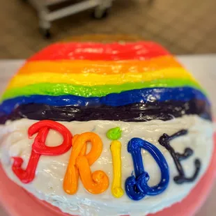 a rainbow cake with the word pride written on it