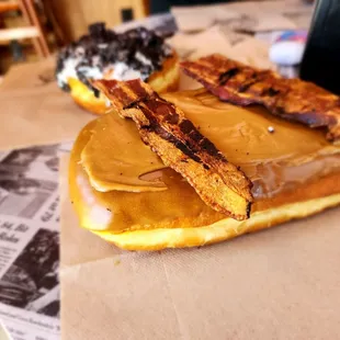 two donuts with bacon on them