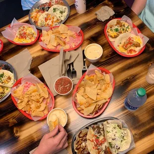 a table full of tacos and nachos