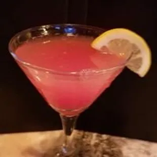 a pink cocktail with a slice of lemon