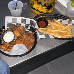 a tray of chicken wings and french fries