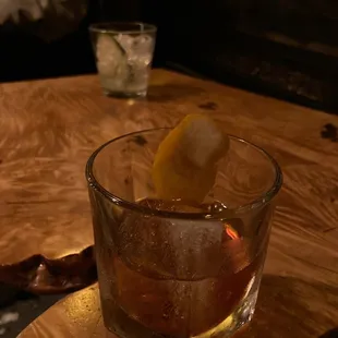 a glass of whiskey with a lemon wedge