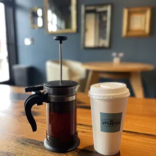 a coffee maker and a cup of coffee