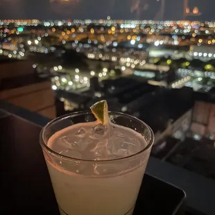 a drink with a view of a city at night