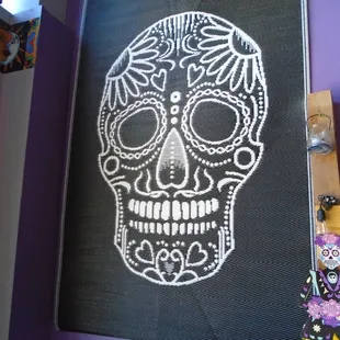 A giant tapestry on the wall with a cool Mexican skull.