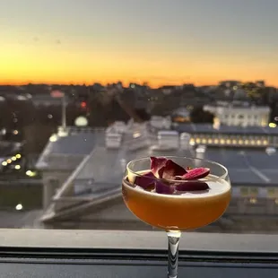 a cocktail in a coupe glass on a window sill