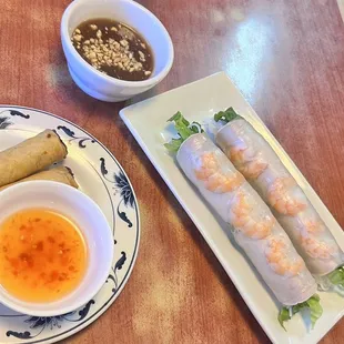 a plate of shrimp spring rolls and a bowl of dipping sauce