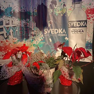 two vases of flowers and a bottle of vodka