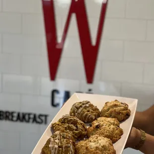 a person holding a plate of pastries