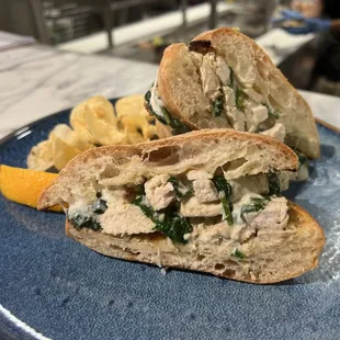 a blue plate with a sandwich and chips