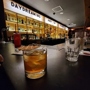 a glass of whiskey on a bar