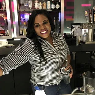 a woman standing behind a bar