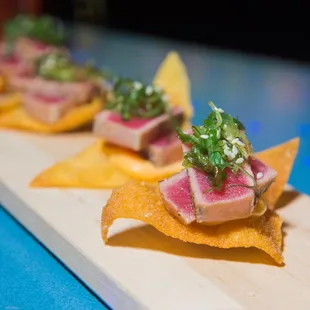 Seared Ahi Tuna Bites over crispy wonton topped with seaweed salad