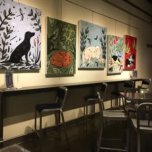 a row of chairs and paintings