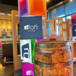 a wooden barrel and a sign for aloft hotel