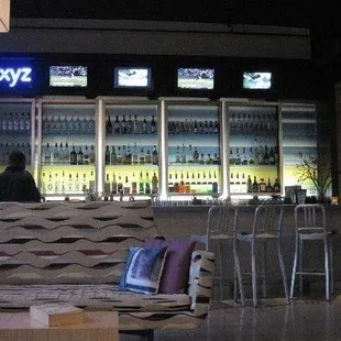 a couch and chairs in front of a bar