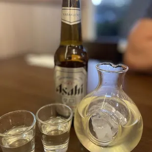 a bottle of beer and two shot glasses