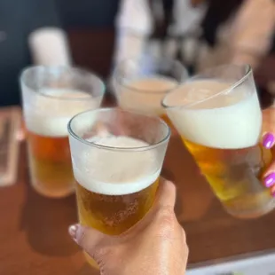 a woman holding two glasses of beer