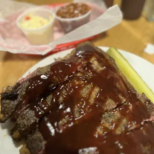 a plate of meat with a pickle
