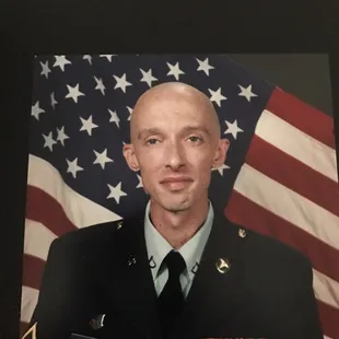 a man in uniform in front of an american flag