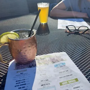 a woman sitting at a table with a drink