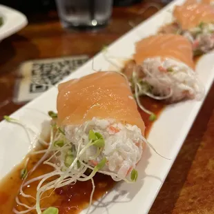 three sushi rolls on a long white plate
