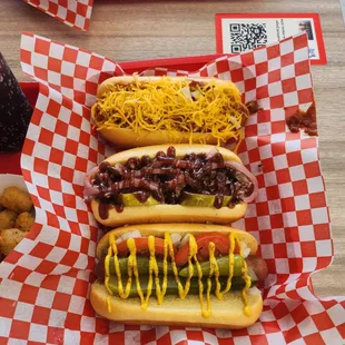 three hot dogs with chili and cheese