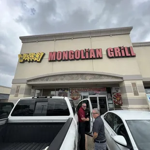 two men standing in front of a restaurant