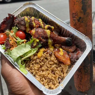 a hand holding a container of food
