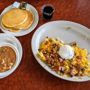 a breakfast of eggs, hash browns, and pancakes