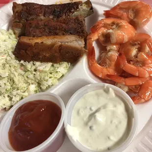 a plate of food with shrimp, coleslaw, and shrimp