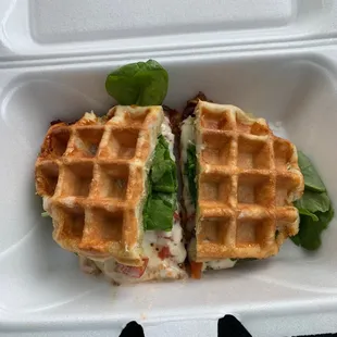 a waffle sandwich in a styrofoam container