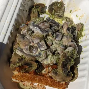a piece of bread with mushrooms and broccoli