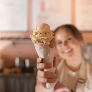 a woman holding a cone of ice cream